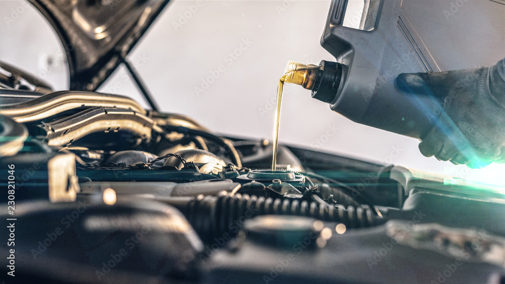 Oil Service - Mechanic fills up the enigne with engine oil - obrazy, fototapety, plakaty 