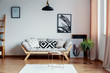 © Photographee.eu - Patterned black and white pillow on beige scandinavian sofa in stylish interior with gallery of poster on the wall and white carpet on wooden floor, real photo