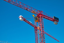 Two Red Cranes Against The Blue Sky
