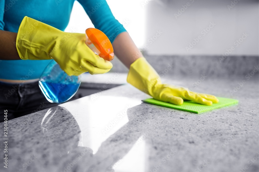 Mid section of woman cleaning kitchen counter - obrazy, fototapety, plakaty 