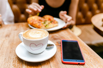 Wall Mural - Woman eating focaccia Pizza and Coffee on wooden table in cafe