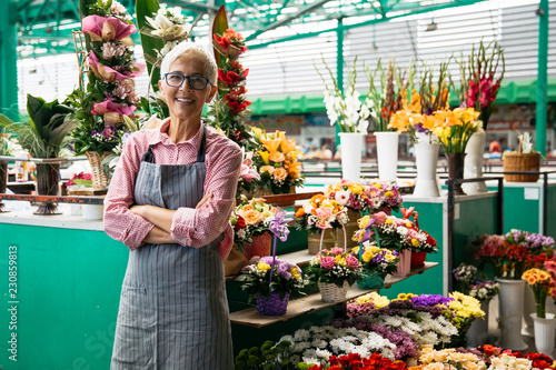 Fotografía Portrait of senior woman sales flowers on local flower market