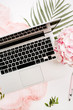 © Floral Deco - Woman home office desk workspace with laptop, pink hydrangea flowers bouquet, pastel blanket, monstera leaf plate and accessories on white background. Flat lay, top view.