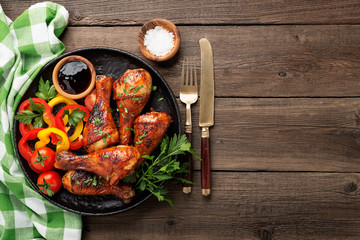 Wall Mural - Grill chicken legs. Grilled chicken legs BBQ with sauce, parsley and tomato.