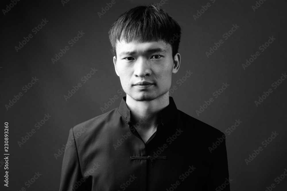Studio shot of young Chinese man in black and white Stock Photo | Adobe ...