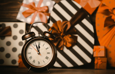 alarm clock and colorful gifts on the brown wooden table