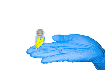 Wall Mural - Close up of female doctor's hand in blue sterilized surgical glove holding white capsule against white background isolate