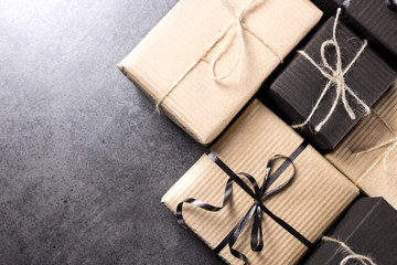 Hand made black and brown gift boxes on dark texture surface.