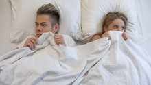 Young Man And Woman Looking Embarrassed Before First Intimacy In Bed, Insecurity