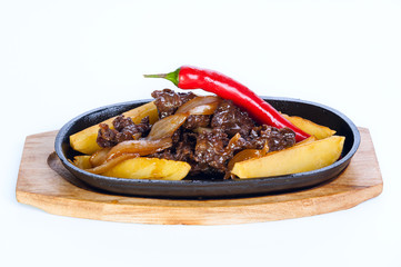 hot frying pan. Roast meat with potatoes and red chili on a white background