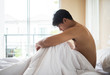 © Johnstocker - Worried man sitting on bed in the morning, serious thinking something