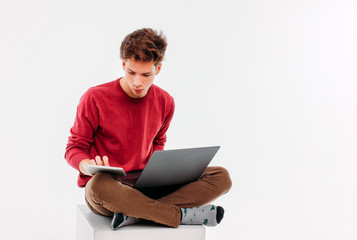 Teenager student with working at laptop and tablet on white background