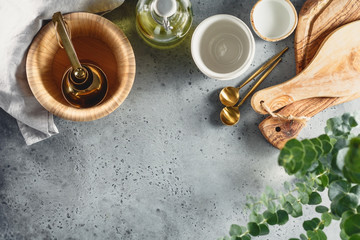 Wall Mural - Modern kitchen metal and wooden utensils on a table for cooking. Golden spoons, bowls and cutting boards. Copy space, top view, flat lay.