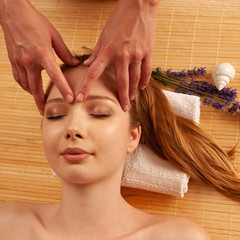 Wall Mural - Beautiful young woman having a face massage in spa salon - wellness