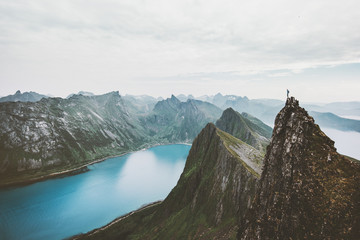 Wall Mural - Norway mountain travel man standing on cliff edge above fjord adventure extreme climbing lifestyle journey vacations solitude emotions silence landscape