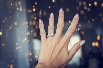 Diamond ring on a finger.