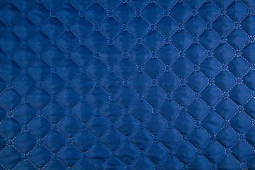  Blue quilted fabric. The texture of the blanket.