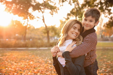 happy mother and son in autumn park