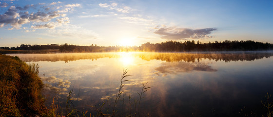 Beautiful morning landscape on a river with mist over the water.