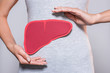 partial view of woman with paper made human liver on grey background