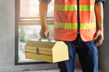 Wall Mural - Close up hands of construction worker holding tools box.