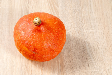 Wall Mural - Top view on ripe orange hokkaido pumpkin on wooden table