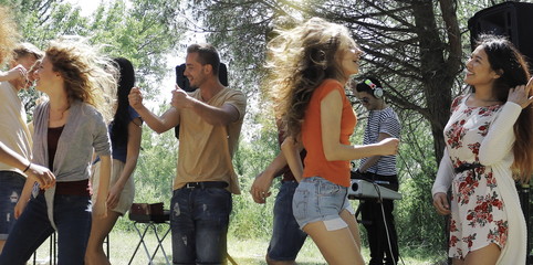 group of friends dance at outdoor party in park