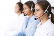 © rogerphoto - Group of callcenter operators at work. Focus at beautiful business woman in headset