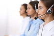 © rogerphoto - Group of callcenter operators at work. Focus at beautiful business woman in headset