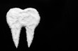 tooth made of sugar on a black background