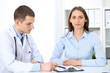© rogerphoto - Friendly male doctor  on the background with patient  and physician