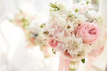 Wedding decor. Bright pink rose bouquet for a bride and bridesmaids stand before a window