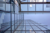 Angled view of a glass wall of an office building. Infinity effect in the blue sky.