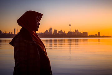 Wall Mural - A pregnant muslim women pose by the Ontario Lake Canada