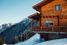 Winter Vacation Holiday Alpine Wooden House Skiing Relax Leisure Resort In The Mountains Covered With Snow And Blue Sky.Dramatic Cottage Scene In Austrian Alps Snowy Panoramic Landscape On A Sunny Day