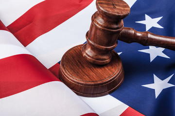 Wooden gavel and USA flag on table close up