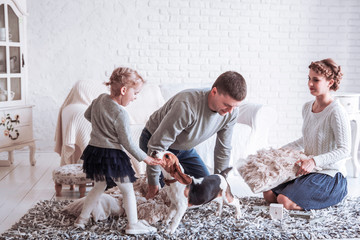 happy family playing with a pet dog in the spacious living room