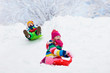 © famveldman - Kids play in snow. Winter sled ride for children
