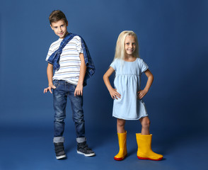 Poster - Cute boy and girl in fashionable clothes on color background