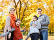 © soleg - Happy family walks in autumn city park. Children and parents posing, smiling, playing and having fun. Bright yellow trees.