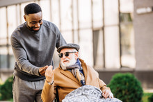 African American Man Giving Joint To Senior Disabled Man In Wheelchair