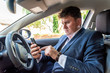 © Jevanto Protography - Businessman texting on smartphone inside car on bright day