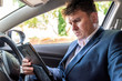 © Jevanto Protography - Businessman working on tablet inside car on bright day