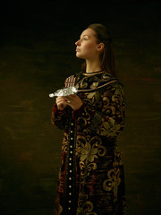 Wall Mural - Girl standing in Russian traditional costume. Woman is wearing in old retro boyary outfit at darl studio