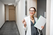 © rh2010 - Portrait of an excited woman with key and documents standing near the dooor of the new apartment in the walkhall