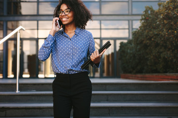 Businesswoman walking outside talking over phone