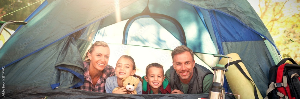 Smiling family lying in the tent - obrazy, fototapety, plakaty 