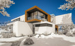 © korisbo - 3d rendering of modern cozy house by the river with garage. Cool winter day with shiny white snow. For sale or rent with beautiful mountains on background