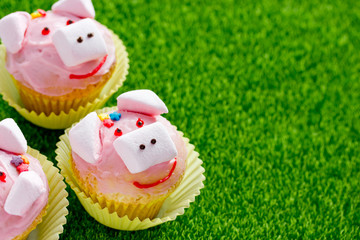 Wall Mural - Pig cupcakes - homemade cakes with pink cream and marshmallow shaped funny piggies for kids party