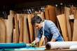 © Stocksy - Male Worker Cutting Textile With Rotary Cutter In Sofa Workshop
